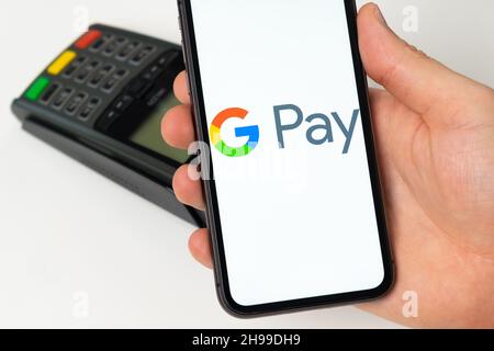 Application mobile Google Pay pour le paiement en ligne.Un homme utilise un téléphone mobile avec une application pour le paiement sécurisé de services ou de marchandises pour le paiement sans contact à l'aide d'un terminal de point de vente.Novembre 2021, San Francisco, États-Unis Banque D'Images