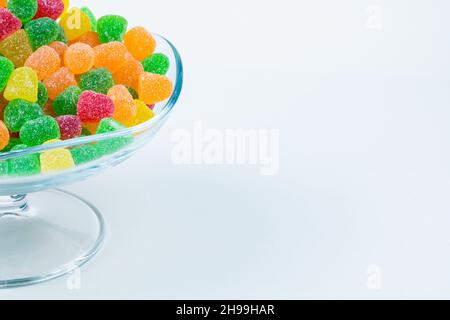 Bonbons gélifiés.Bonbons gélifiés dans un bol en verre avec espace de copie isolé sur fond blanc. Banque D'Images