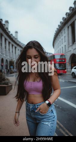 Portrait d'une jeune femme brune adulte portant un Jean avec un petit top dans les rues de Londres Banque D'Images