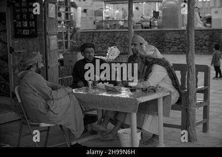 Groupe de pêcheurs arabes traditionnels assis dans le village culturel de Katara à Doha, Qatar image monochrome pendant le festival traditionnel de dhow de Katara Banque D'Images