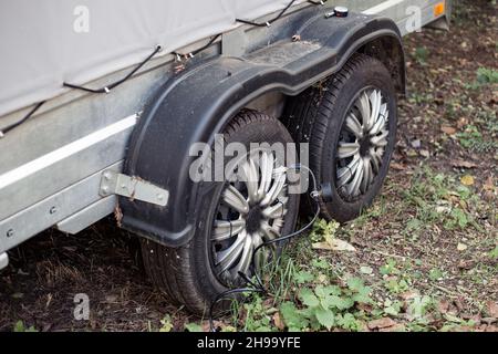 Gonflage des roues d'une remorque auto à deux essieux avec un compresseur d'air électrique portatif.Entretien et réparation des pneus.Russie, Anapa-09.10.2021. Banque D'Images