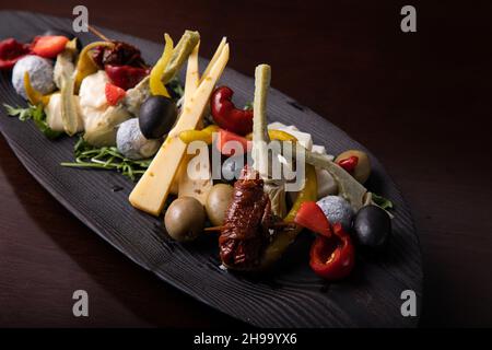 Palette de nombreux types de fromage et quelques légumes, tomates, paprika, olives. Banque D'Images