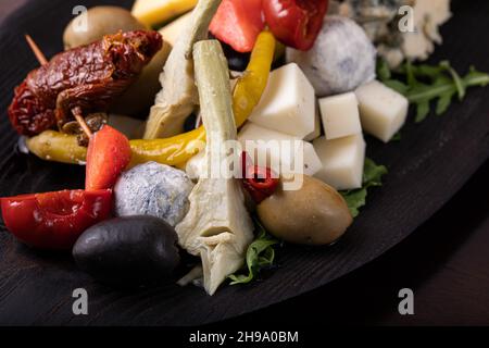 Palette de nombreux types de fromage et quelques légumes, tomates, paprika, olives. Banque D'Images