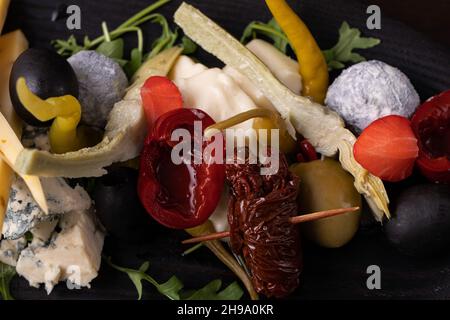 Palette de nombreux types de fromage et quelques légumes, tomates, paprika, olives. Banque D'Images