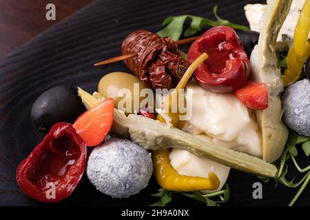 Palette de nombreux types de fromage et quelques légumes, tomates, paprika, olives. Banque D'Images