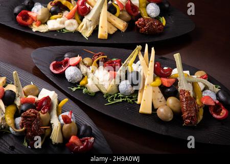Palette de nombreux types de fromage et quelques légumes, tomates, paprika, olives. Banque D'Images