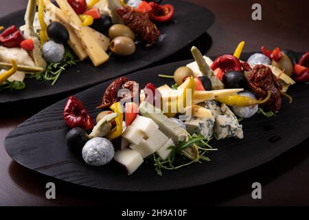 Palette de nombreux types de fromage et quelques légumes, tomates, paprika, olives. Banque D'Images