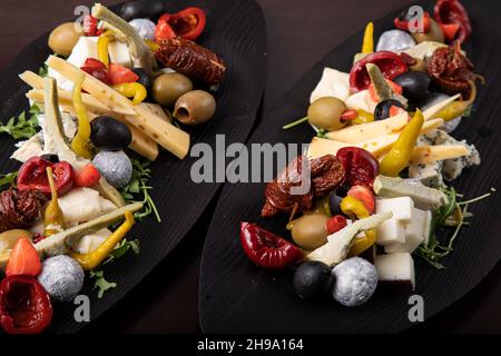 Palette de nombreux types de fromage et quelques légumes, tomates, paprika, olives. Banque D'Images
