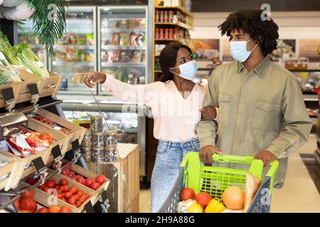 Black couple faire des courses en magasin, porter des masques Banque D'Images