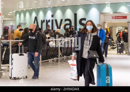 Les passagers aériens se retrouvent dans le hall des arrivées de l'aéroport de Londres Heathrow au milieu de la propagation d'Omicron , requise pour effectuer un test PCR en Angleterre Banque D'Images