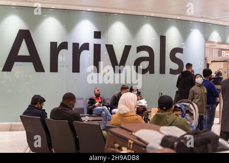 Les passagers aériens se retrouvent dans le hall des arrivées de l'aéroport de Londres Heathrow au milieu de la propagation d'Omicron , requise pour effectuer un test PCR en Angleterre Banque D'Images