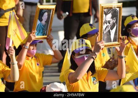 Bangkok, Thaïlande.5 décembre 2021.Les gens fidèles à porter des chemises jaunes et à montrer des photos de monarques thaïlandais attendant la procession de la voiture royale du roi thaïlandais sur la route Ratchadamnoen tandis que la procession de la voiture royale passe au Grand Palais à l'occasion de l'anniversaire de sa Majesté le Roi tardifBhumibol Adulyadej le Grand, la Journée nationale de la Thaïlande et la Journée des pères de la Thaïlande.(Credit image: © Teera Noisakran/Pacific Press via ZUMA Press Wire) Banque D'Images