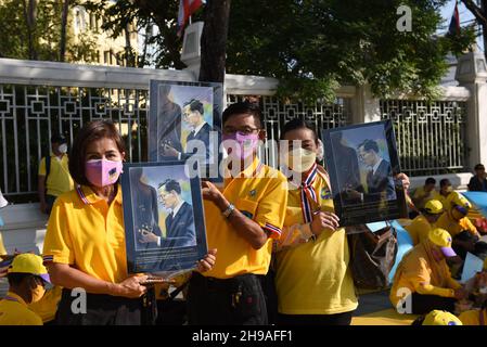 Bangkok, Thaïlande.5 décembre 2021.Les gens fidèles à porter des chemises jaunes et à montrer des photos de monarques thaïlandais attendant la procession de la voiture royale du roi thaïlandais sur la route Ratchadamnoen tandis que la procession de la voiture royale passe au Grand Palais à l'occasion de l'anniversaire de sa Majesté le Roi tardifBhumibol Adulyadej le Grand, la Journée nationale de la Thaïlande et la Journée des pères de la Thaïlande.(Credit image: © Teera Noisakran/Pacific Press via ZUMA Press Wire) Banque D'Images