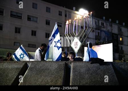 Chef d'équipe en service, Israël.5 décembre 2021, l'aile droite religieuse israélienne marche en public avec des drapeaux à travers la ville mixte de Lod, célébrant la dernière bougie de la fête de Hanoukkah.L'événement a été organisé par des groupes sionistes religieux, certains d'entre eux percived comme radicaux en Israël, visant à étendre le présent juif dans le pays.La ville de Lod est peuplée à la fois de juifs et de musulmans, qui vivaient en paix jusqu’à l’arrivée d’un « noyau de la Torah » dans la ville.Credit: Matan Golan/Alay Live News Banque D'Images