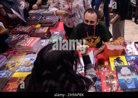 Rome, Italie.05e décembre 2021.Le caricaturiste italien Michele Rech, également connu sous le nom de Zerocalcare, signe une copie d'un livre par lui à un fan,Lors de la Foire nationale des petites et moyennes éditions 'Più Libri Più Liberi'.'Più Libri Più Liberi' est la première foire italienne entièrement dédiée à l'édition où chaque année environ 500 éditeurs, venant de toute l'Italie, présentent leurs nouvelles et leur catalogue au public.Crédit : SOPA Images Limited/Alamy Live News Banque D'Images