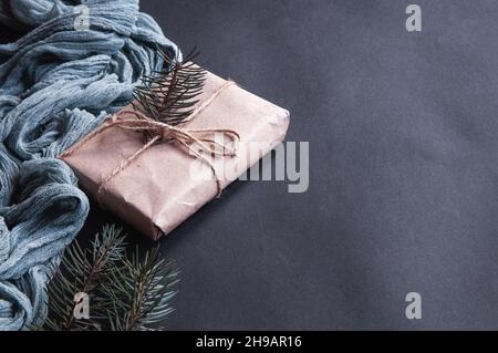 Fond gris froissé avec une toile de gaze bleue, avec des branches d'épinette.Boîte cadeau à côté de la nappe vintage grise et feuilles d'arbre de noël sur le bois de la Bro Banque D'Images