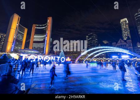 Les gens qui font du patinage sur glace à Nathan Phillips Square pendant la nuit d'hiver pendant la période pandémique Covid-19.Toronto, Ontario, Canada. Banque D'Images