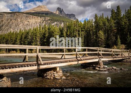 Un pont en bois au-dessus d'un ruisseau de montagne clair dans le parc national Banff Canada. Banque D'Images