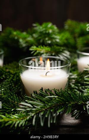 Bougie lumineuse dans les branches de pin vert.Arrière-plan de Noël.Mise au point sélective. Banque D'Images