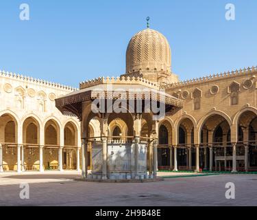 Fontaine d'ablution servant de support à la cour de la mosquée historique publique du Sultan al Muayyad, avec arrière-plan de couloirs voûtés entourant la cour, et dôme de la mosquée, le Caire, Egypte Banque D'Images