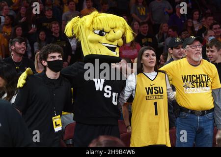 Wichita, Kansas, États-Unis.05e décembre 2021.WuShok la mascotte des shockers de l'État de Wichita se joint à trois fans pour chanter la schoo pendant le match de basket-ball de la NCAA entre les Wildcats de l'État du Kansas et les shockers de l'État de Wichita à l'Intrust Bank Arena de Wichita, au Kansas.Kendall Shaw/CSM/Alay Live News Banque D'Images