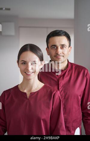 Deux nettoyeurs en uniforme posant pour la caméra sur le lieu de travail Banque D'Images