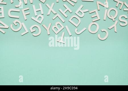 pile de lettres en bois tombant sur fond de papier bleu Banque D'Images