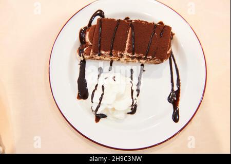 Tiramisu sur un plat blanc à la crème et au chocolat, dessert italien.Fermer la vue Banque D'Images