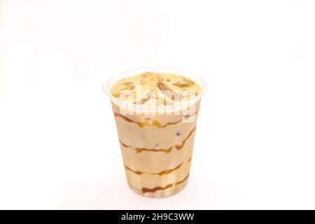 Latte glacé au caramel servi dans une tasse de café jetable. Banque D'Images