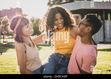 trois heureux amis souriant, coucher de soleil sur le dos Banque D'Images