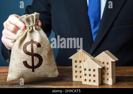 Dollars des sacs d'argent et des chiffres de bâtiments résidentiels.Investissements dans l'immobilier et l'industrie de la construction.Taxes.Offre bancaire de prêt hypothécaire.Municip Banque D'Images