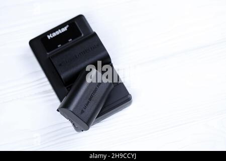 KHARKOV, UKRAINE - 14 MARS 2021 : batteries Kastar au lithium-ion ou au lithium-ion pour photocameras DSLR modernes sur table en bois blanc Banque D'Images