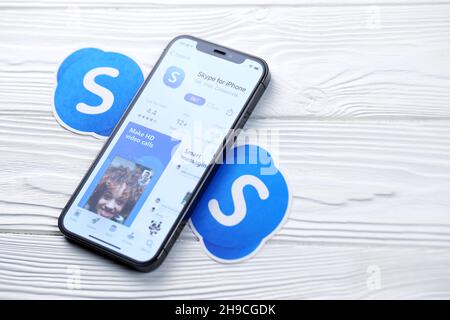 KHARKOV, UKRAINE - 5 MARS 2021 : icône Skype et application de l'App Store sur l'iPhone 12 pro écran d'affichage sur table en bois blanc Banque D'Images
