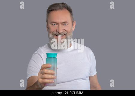 Homme barbu tenant une bouteille d'eau Banque D'Images
