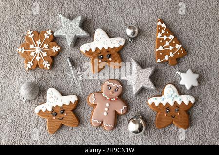 Ensemble plat de biscuits au gingembre et à la cannelle : pain d'épice, flocons de neige, étoiles décorées de glaçage sur fond gris Banque D'Images