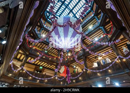 Londres, Royaume-Uni.6 décembre 2021.Une vue générale des décorations de Noël dans le magasin Liberty en forme de ballon à air chaud suspendu géant, qui porte un message « choisi avec amour, estampillé avec magie ».Les clients doivent se préparer à la période de vente de Noël, avec pour toile de fond un nombre croissant de caisses Omicron.Credit: Stephen Chung / Alamy Live News Banque D'Images