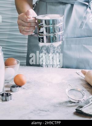 Femme Chef soupira la farine, pétrit la pâte.Concept de boulangerie ou de pâtisserie.Ingrédients pour la pâte Banque D'Images