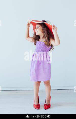 petite fille de 5 ans dans une robe et des chaussures de sa mère Banque D'Images