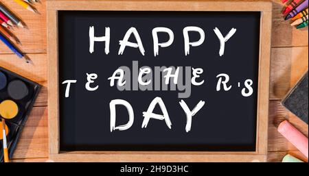 Image composite du texte de la journée des enseignants heureux sur l'ardoise d'écriture avec les fournitures scolaires Banque D'Images