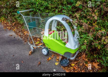 Un chariot à provisions de Morrisons abandonné avec une poussette pour enfants attachée à l'avant avec une roue avant cassée jetée dans un parking, 7 novembre 2021 Sidcup Banque D'Images