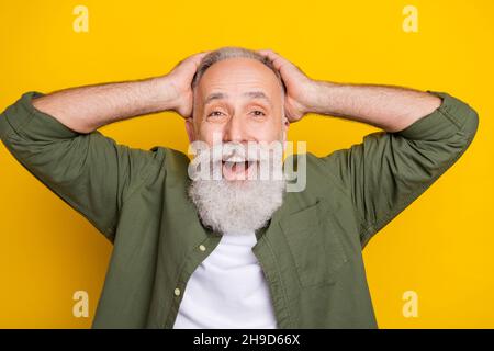 Photo portrait de grand-père en gardant la tête souriante stupéfait isolé couleur jaune vif fond Banque D'Images