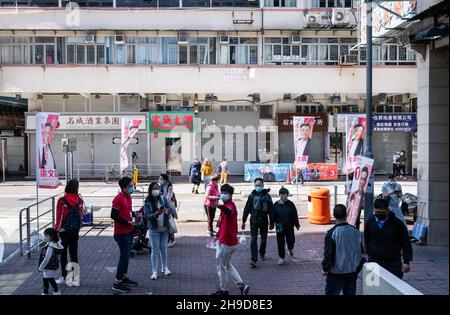 Hong Kong, Chine.05e décembre 2021.Les piétons se promeuvent devant les travailleurs de campagne vus en faveur de la candidate Leung Man-kwong pour les prochaines élections législatives du Conseil prévu le 19 décembre, à Hong Kong.Crédit : SOPA Images Limited/Alamy Live News Banque D'Images