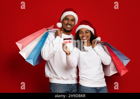 Joyeux afro-américain jeune homme et femme achetant des cadeaux de Noël Banque D'Images