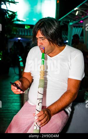 Odessa, Ukraine 28 juin 2013 : boîte de nuit d'Ibiza.Les personnes qui fument du narguilé pendant un concert en boîte de nuit.L'homme s'amuse au club Banque D'Images