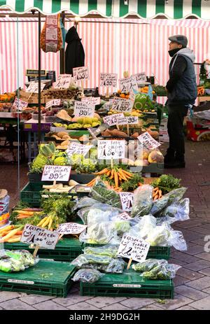 Négociant de marché au Royaume-Uni; un greengrocer vendant des fruits et des légumes de sa stalle alimentaire, marché de Saffron Walden, Saffron Walden Essex au Royaume-Uni Banque D'Images