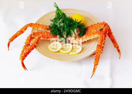 Le crabe royal rouge sur une plaque avec du citron et l'aneth. Fond blanc Banque D'Images
