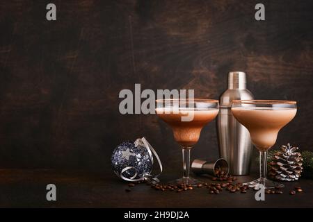 Alexander cocktail en verre cocktail sur table en bois avec shaker, noix de muscade et petit râpe avec décoration de Noël sur fond sombre.Photographie de boisson Banque D'Images