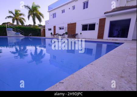 Piscine profonde de 25 mètres de long avec plongeoir.La piscine est située à l'extérieur du complexe résidentiel.Piscine au milieu de palmiers exotiques, à côté de bui blanc Banque D'Images