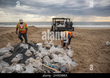 Une équipe de nettoyage nettoie les gisements de pétrole et de goudron, et se hale d'une berme construite pour empêcher l'huile de s'écouler dans la rivière Santa Ana, qui normalement Banque D'Images