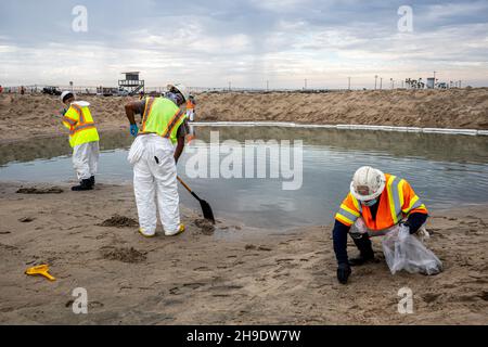 Une équipe de nettoyage nettoie les gisements de pétrole et de goudron, et se hale d'une berme construite pour empêcher l'huile de s'écouler dans la rivière Santa Ana, qui normalement Banque D'Images